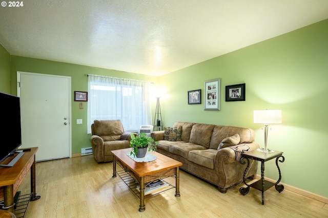 living room with light hardwood / wood-style floors, a textured ceiling, and a baseboard radiator