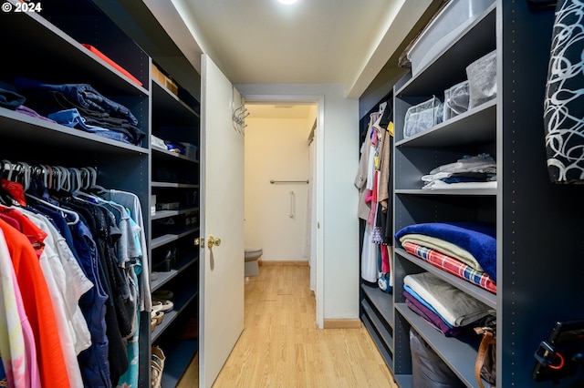 walk in closet with wood finished floors