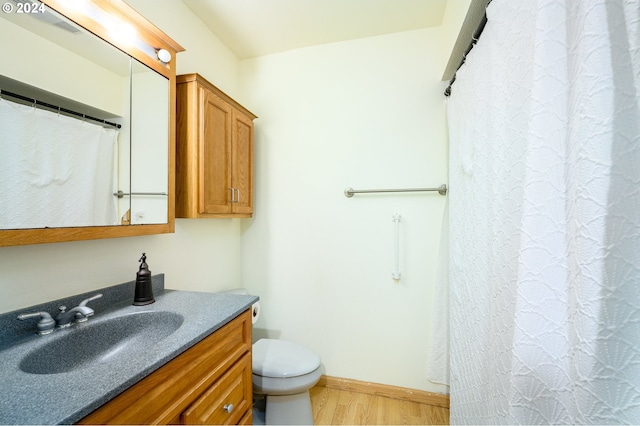 bathroom featuring vanity, toilet, hardwood / wood-style flooring, and curtained shower