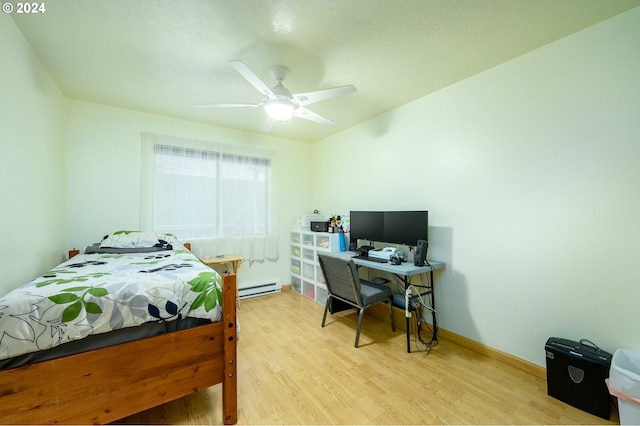bedroom with a baseboard radiator, light wood-style flooring, a ceiling fan, and baseboards