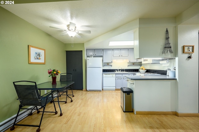 kitchen featuring a peninsula, light wood-style floors, a ceiling fan, and white appliances