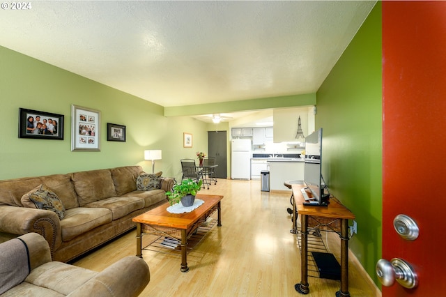 living room with light wood-type flooring and a ceiling fan
