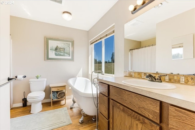 bathroom featuring hardwood / wood-style floors, vanity, toilet, and a healthy amount of sunlight