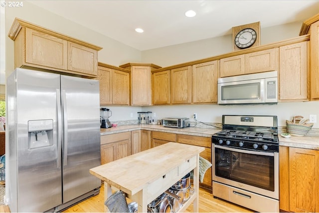 kitchen with light brown cabinetry, light hardwood / wood-style flooring, and appliances with stainless steel finishes