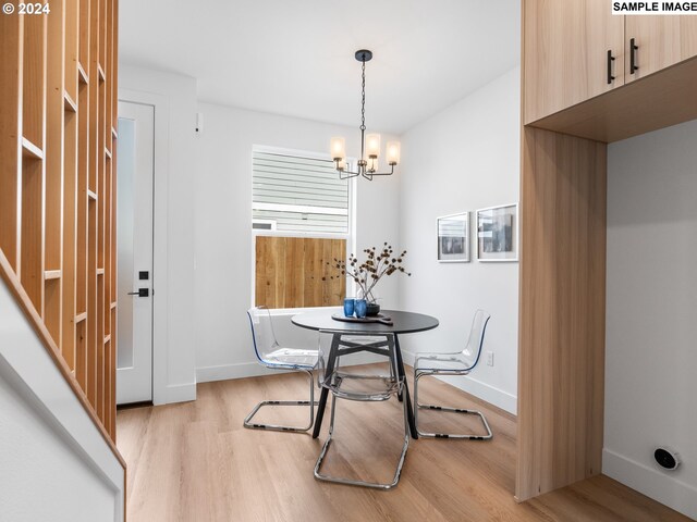 dining area with a notable chandelier and light hardwood / wood-style flooring