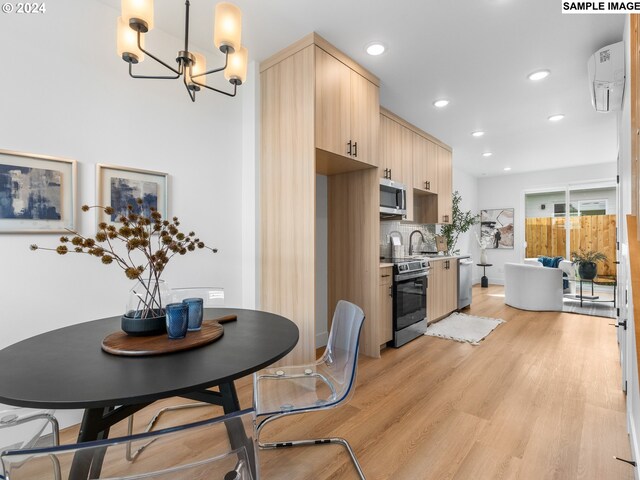 dining area featuring an inviting chandelier, light hardwood / wood-style floors, and sink