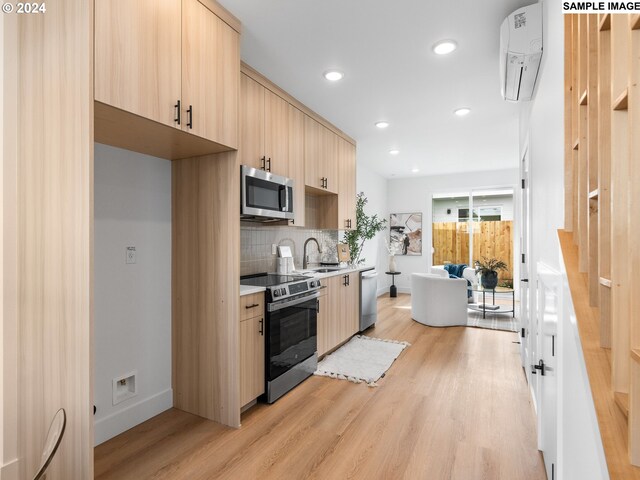 kitchen featuring light hardwood / wood-style flooring, light brown cabinets, appliances with stainless steel finishes, and tasteful backsplash