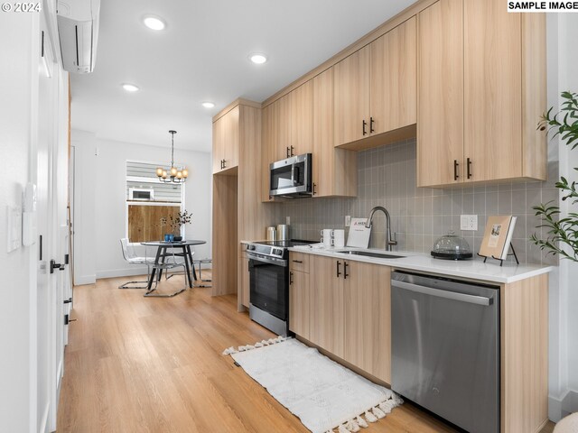 kitchen featuring light brown cabinetry, appliances with stainless steel finishes, sink, and light hardwood / wood-style flooring