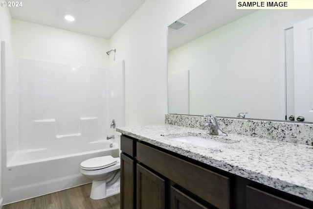 full bathroom featuring hardwood / wood-style floors, vanity, toilet, and shower / bath combination