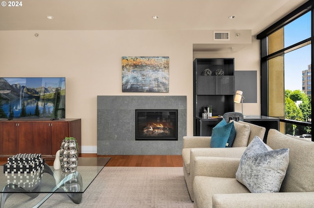 living room with light hardwood / wood-style flooring, a wealth of natural light, and floor to ceiling windows