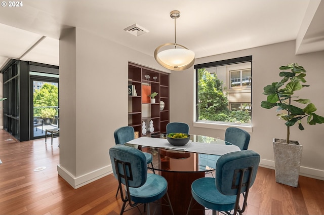 dining space with wood-type flooring