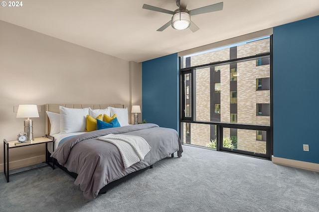 carpeted bedroom featuring floor to ceiling windows and ceiling fan