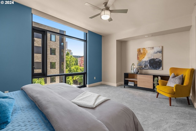 bedroom featuring a wall of windows, carpet, and ceiling fan