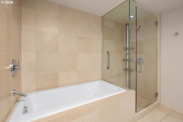 bathroom featuring plus walk in shower and tile patterned flooring