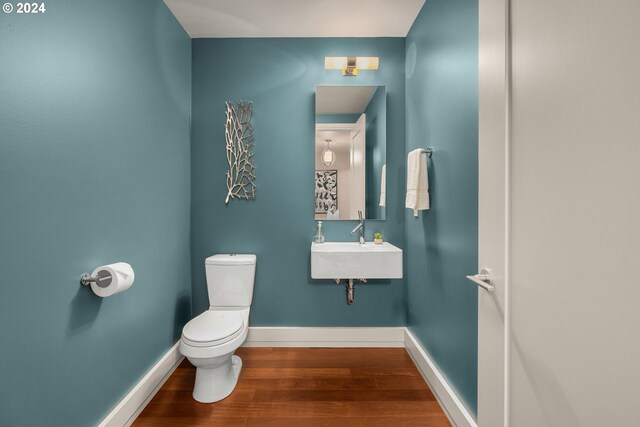 bathroom featuring sink, toilet, and wood-type flooring