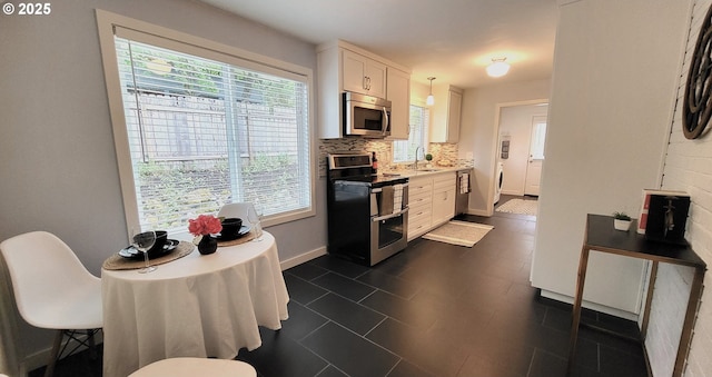 1400 W 40th St, Eugene, OR 97405 - kitchen featuring appliances with stainless steel finishes, plenty of natural light, white cabinetry, and a sink
