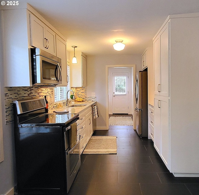 1400 W 40th St, Eugene, OR 97405 - kitchen featuring appliances with stainless steel finishes, a sink, decorative backsplash, white cabinetry, and light countertops