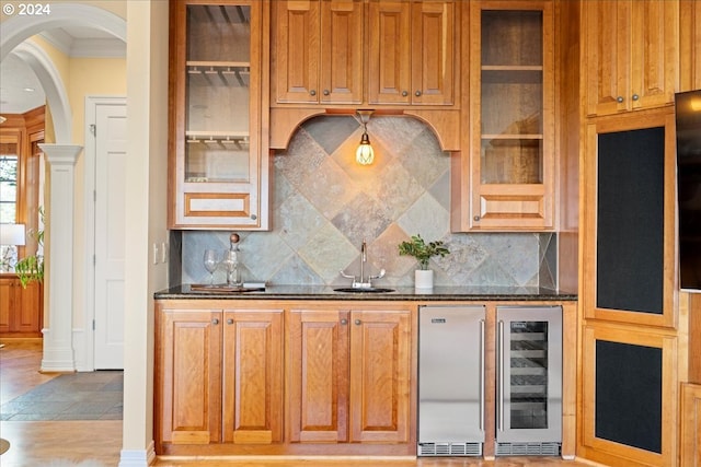 kitchen with dark stone counters, wine cooler, backsplash, and ornamental molding