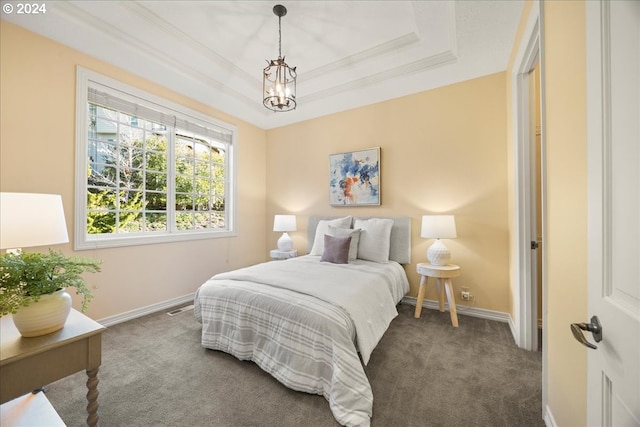 bedroom with a chandelier, a raised ceiling, dark carpet, and ornamental molding