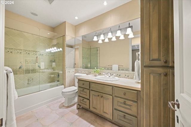 full bathroom featuring vanity, bath / shower combo with glass door, tile patterned flooring, and toilet