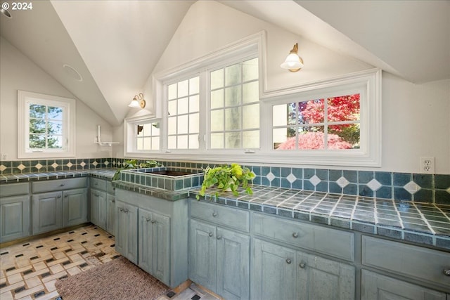 kitchen featuring gray cabinets, plenty of natural light, and vaulted ceiling