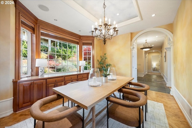 dining space with a tray ceiling and an inviting chandelier