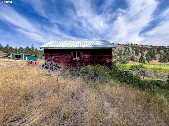 view of side of home with an outbuilding and metal roof