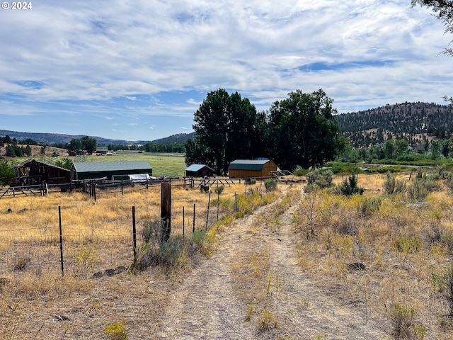 view of street with a pole building, a rural view, and a mountain view