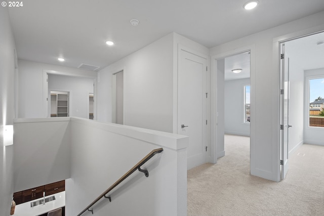 hallway featuring light colored carpet