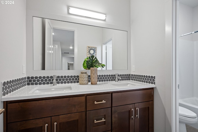 bathroom with tasteful backsplash, vanity, and toilet