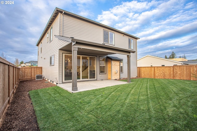 back of house with central AC unit, a patio area, and a yard