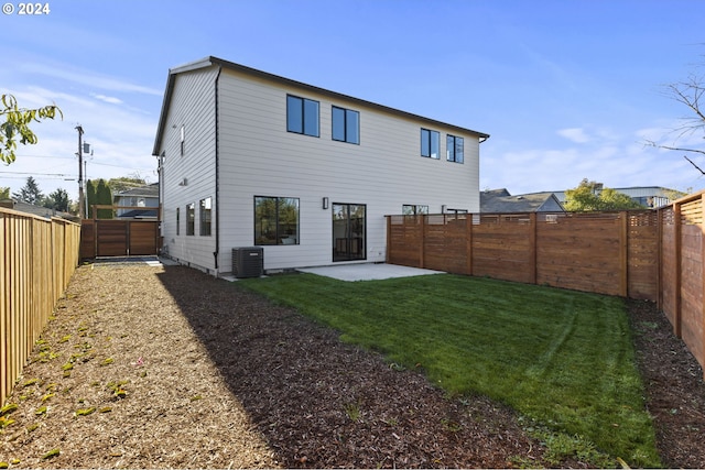 rear view of property featuring central air condition unit, a yard, and a patio