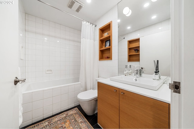 full bathroom featuring tile walls, toilet, tile patterned floors, vanity, and tiled shower / bath