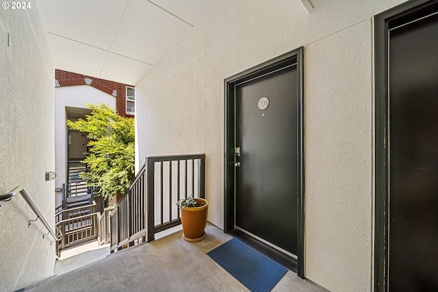 property entrance with stucco siding and a balcony