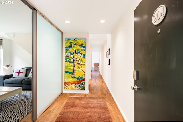 corridor featuring recessed lighting, baseboards, and light wood-style floors