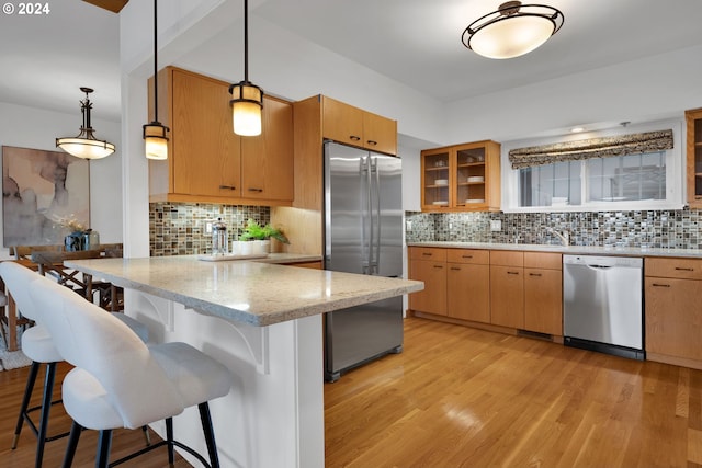 kitchen featuring decorative light fixtures, appliances with stainless steel finishes, and tasteful backsplash