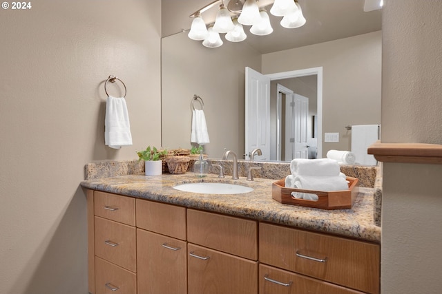 bathroom with vanity and a notable chandelier