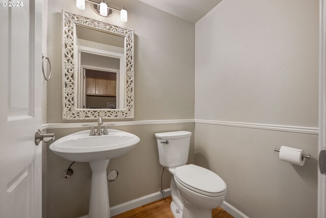 bathroom featuring hardwood / wood-style flooring, toilet, and sink