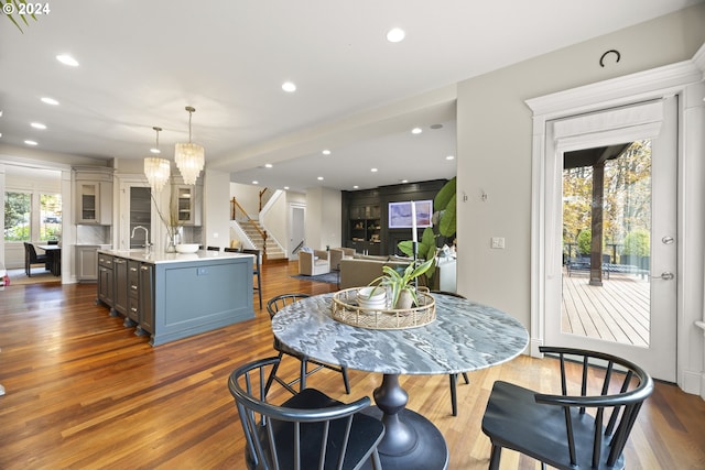 dining area with a chandelier, sink, a wealth of natural light, and hardwood / wood-style floors