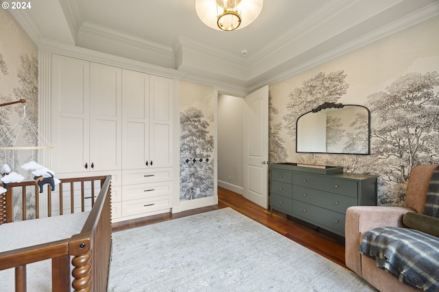 bedroom featuring ornamental molding, dark hardwood / wood-style floors, and a raised ceiling