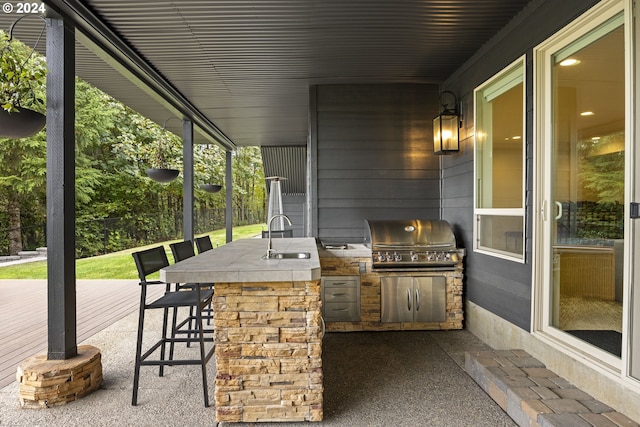 view of patio / terrace featuring area for grilling, a wet bar, and exterior kitchen