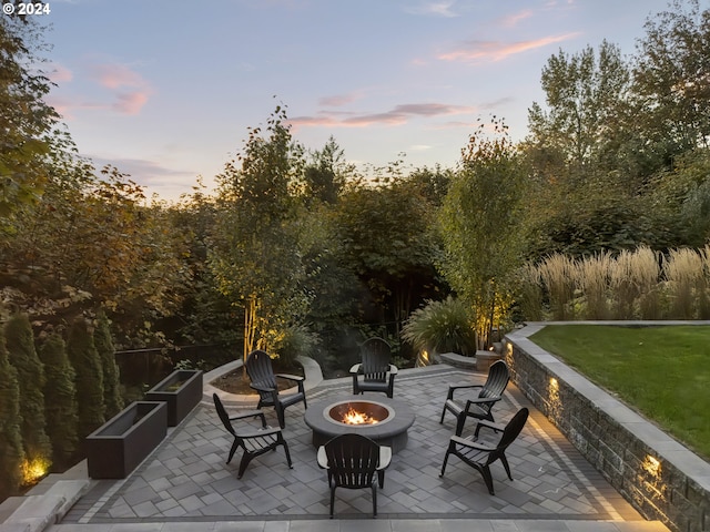 patio terrace at dusk with a lawn and a fire pit