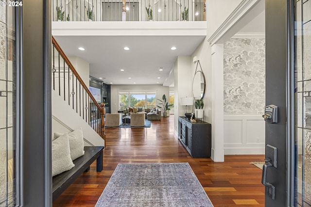 foyer with ornamental molding and dark hardwood / wood-style floors