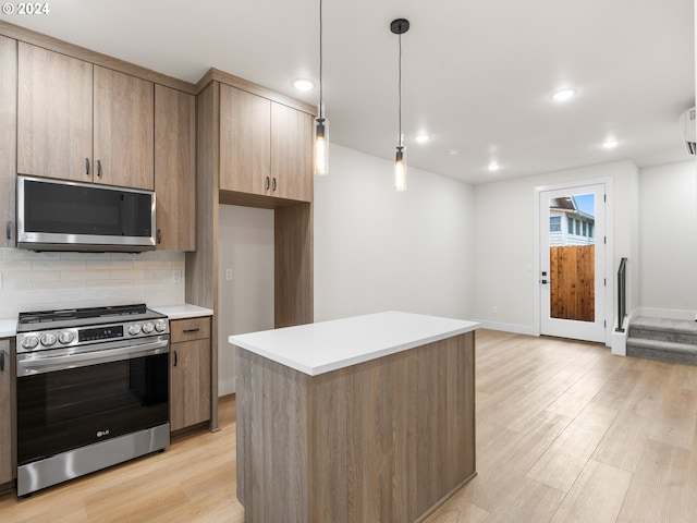 kitchen featuring appliances with stainless steel finishes, tasteful backsplash, decorative light fixtures, light hardwood / wood-style flooring, and a center island