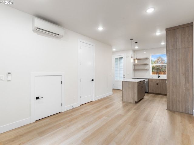 kitchen with a kitchen island, light wood-type flooring, pendant lighting, dishwasher, and a wall unit AC