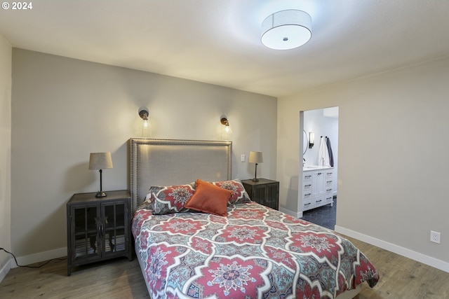 bedroom with dark hardwood / wood-style flooring and connected bathroom