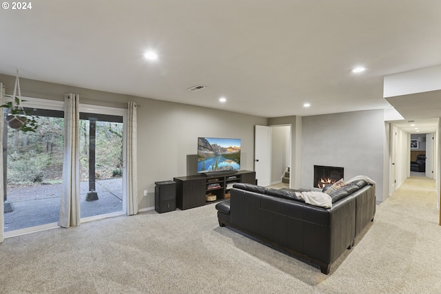 carpeted living room featuring a large fireplace