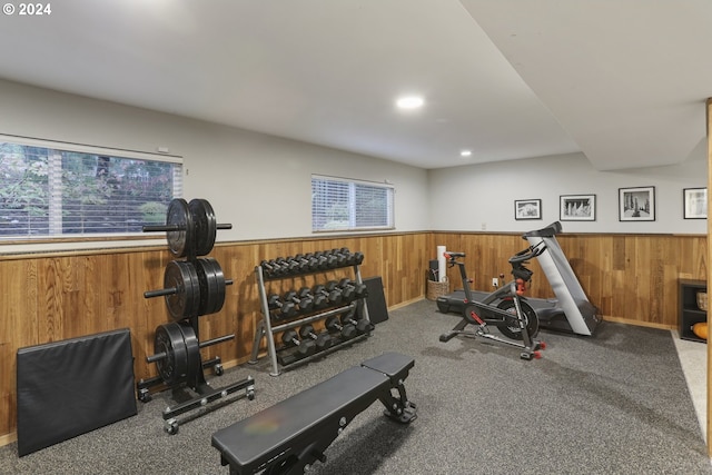 workout room with carpet and wood walls