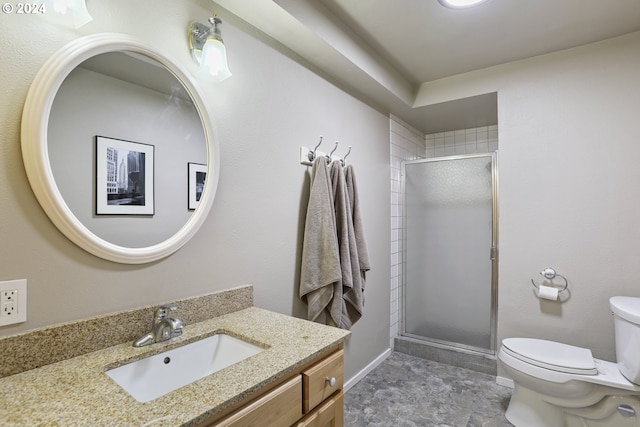 bathroom with vanity, a shower with shower door, and toilet