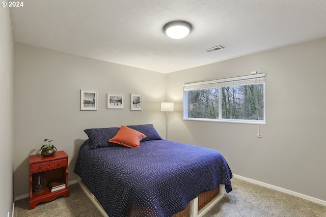 bedroom with carpet and a textured ceiling